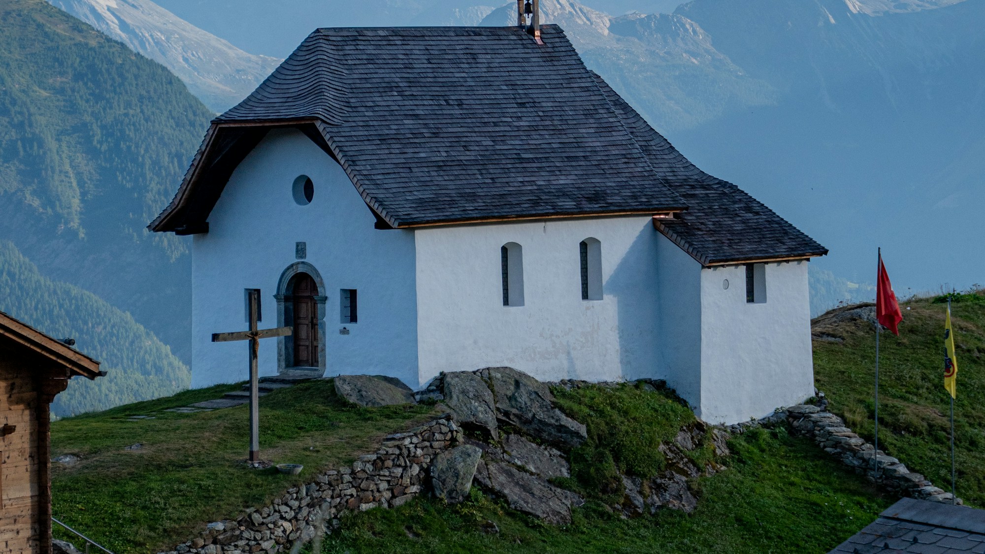 Kleine weisse Kapelle auf einer Bergwiese